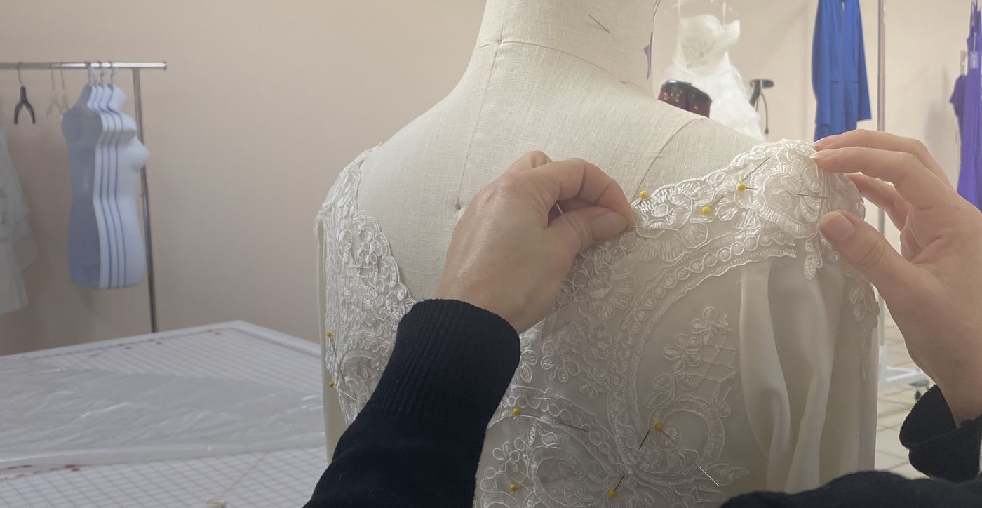 Hands working with lace fabric in the studio